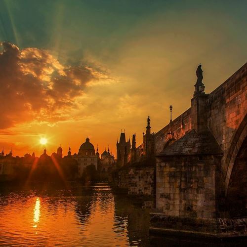 eine Brücke über das Wasser mit einem Sonnenuntergang dahinter
